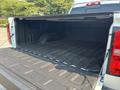 A 2017 Chevrolet Silverado 1500 truck bed featuring a black rubber liner and clean interior space without any cargo inside