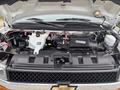 The image shows the engine compartment of a 2020 Chevrolet Express with visible components including the engine block coolant reservoir and various hoses and wiring