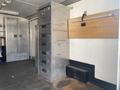 A stainless steel storage unit with multiple drawers and a countertop area in a vehicle or trailer interior