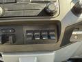 Close-up of the control panel in a 2012 Ford F-350 SD featuring four auxiliary switches and various knobs for adjusting settings