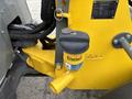 A yellow and gray Wacker Neuson WL34 construction machine showing a diesel fuel filter with a black cap and hoses attached