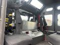 Interior of a 2006 E-One Typhoon fire truck featuring two black fabric seats and a metal control panel with various switches and equipment