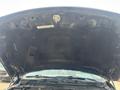 View of the underside of a black hood of a 2015 RAM 1500 pickup truck with engine components partially visible