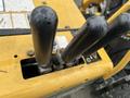 Close-up of the control levers on a 2014 Vermeer Corporation Sweep Stump Cutter showcasing the black handles and the labeled panel on the machine's surface