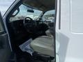 Interior view of a 2022 GMC Savana showing the driver's seat and dashboard with steering wheel and gear shift visible