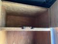 Interior view of a wooden cabinet with no contents visible featuring a shelf inside and a smooth wooden finish