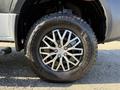 A close-up view of a black tire with a multi-spoke silver alloy rim featuring "Goodyear Wrangler" branding on the sidewall