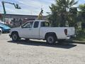 A white 2011 Chevrolet Colorado pickup truck parked with a cargo bed and extended cab visible