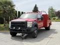 A red 2013 Ford F-550 with a flatbed design and front fog lights is shown in the foreground