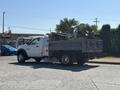 A 2016 RAM 5500 truck with a dump bed filled with scrap metal and debris parked on a paved area
