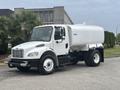 A 2006 Freightliner M2 106 truck with a white tank body and black chassis designed for hauling liquids or other materials