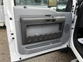 Close-up of the door panel of a 2012 Ford F-550 featuring a gray plastic handle and storage compartment with ridges and a textured surface