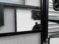 A close-up view of the door entry area of a 2021 Jayco Jay Flight featuring a black handle and locking mechanism on a textured surface