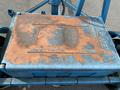 A weathered blue metal box with rust patches and the word "VERTIC" embossed on the surface top of a 2003 U-Built Reel Trailer