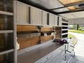 Interior view of a 2011 Workhorse W62 with metallic shelving and storage compartments including drawers and wooden surfaces