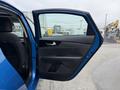 A blue 2021 Kia Forte with the driver's side door open showcasing the interior door panel and seat