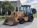 A 2005 Case 570 tractor with a front loader attachment and large tires in a work-ready position