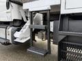 A black metal step ladder attached to the side of a 2015 Freightliner M2 truck for easy access to the vehicle's cab