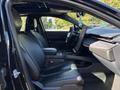 Interior view of a 2023 Fisker Ocean showcasing front black leather seats and a sleek dashboard with a large touchscreen display