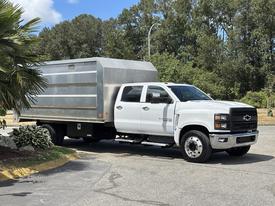 A 2020 Chevrolet Silverado truck with a silver cargo box attached to the bed parked at an angle