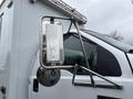 Close-up of the side mirror of a 2011 Ford F-650 showing a metallic frame and a clear mirror surface with raindrops on it