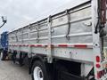 A 2017 Autocar Xpert truck with a silver dump body featuring metallic siding and red reflective stripes on the side