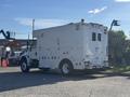 A white 2008 International 4400 truck with a utility body featuring numerous compartments and a light bar on top parked at an angle