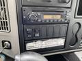 Dashboard of a 2014 International Durastar featuring a radio display and control buttons including dump and park brake settings