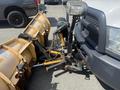 A 2016 RAM 5500 truck equipped with a yellow snow plow attached to the front, featuring a metal frame and chains for securing the blade
