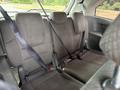The interior of a 2014 Honda Odyssey showing the backseat with three seatbelts secured on gray fabric seats