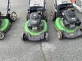 Three Honda Lawnboy mowers with green bases and two Stihl line trimmers arranged in a row