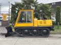A yellow 2004 Bombardier SW48 snow grooming machine with tracks and a front plow attachment