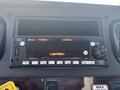 A dashboard control unit with a display screen buttons for audio control USB port and Bluetooth functionality in a 2022 Freightliner M2 106