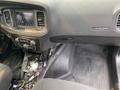 Interior view of a 2019 Dodge Charger with a touchscreen display and control knobs visible along with exposed wiring on the floor