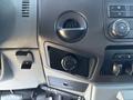 Dashboard controls of a 2011 Ford F-550 including air vent knobs radio buttons and a compartment for storage