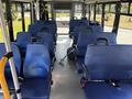 Interior view of a 2020 Chevrolet Express bus with several blue passenger seats arranged in rows