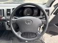 Steering wheel of a 2009 Toyota Hiace with the Toyota logo at the center and various controls on the wheel