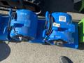 A collection of blue dehumidifiers and air movers with visible markings and labels in a line on a surface