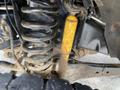Close-up of a suspension system showcasing a black coil spring and a yellow shock absorber on a 2015 Ford F-550