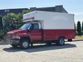 A red and white 2007 GMC C4500 TopKick box truck with a large cargo area and multiple lights on the roof