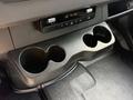 A close-up view of a cup holder section in a 2023 Mercedes-Benz Sprinter with two circular cup holders and control panel above