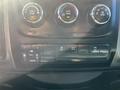 Dashboard controls of a 2015 RAM 1500 featuring climate control knobs and buttons for towing and rear parking assistance