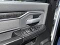 Interior view of a 2021 RAM 5500 door panel featuring a door handle and window control buttons in a textured gray finish