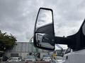 A side mirror of a 2018 Ford F-750 showing a clear reflection of the sky and surrounding objects