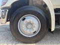 Close-up of a wheel from a 2012 Hino 338 featuring a silver rim and multiple lug nuts on a large black tire