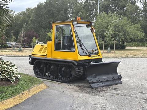 A yellow 2004 Bombardier SW48 snowplow with a front blade and tracks designed for snow removal