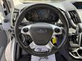 A close-up view of the steering wheel of a 2016 Ford Transit featuring the Ford logo and various control buttons on the wheel