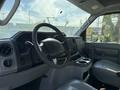 Interior view of a 2012 Ford Econoline E-450 showing the dashboard steering wheel and front seating area