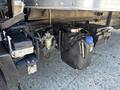 A close-up view of the undercarriage of a 2022 Isuzu NQR showing a fuel tank and associated components