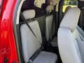Interior view of a 2018 GMC Canyon showing two gray fabric seats with seat belts and headrests in a spacious cabin design